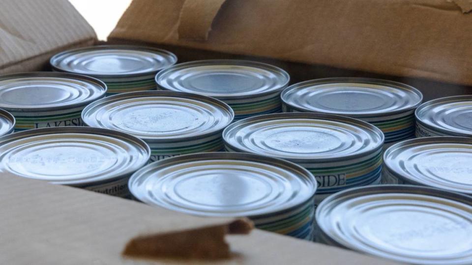 Canned meat is unloaded from a box at the St. Vincent de Paul Overland food pantry.