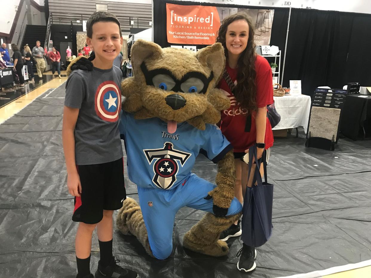 Andy Barnes, 12, and aunt MacKenzie Marcrum visit with T-Rac, the Titans mascot at Experience Spring Hill.