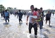 Migrants, part of a caravan travelling to the U.S, cross the Suchiate river from Tecun Uman, in Guatemala, to Ciudad Hidalgo, as seen from Ciudad Hidalgo