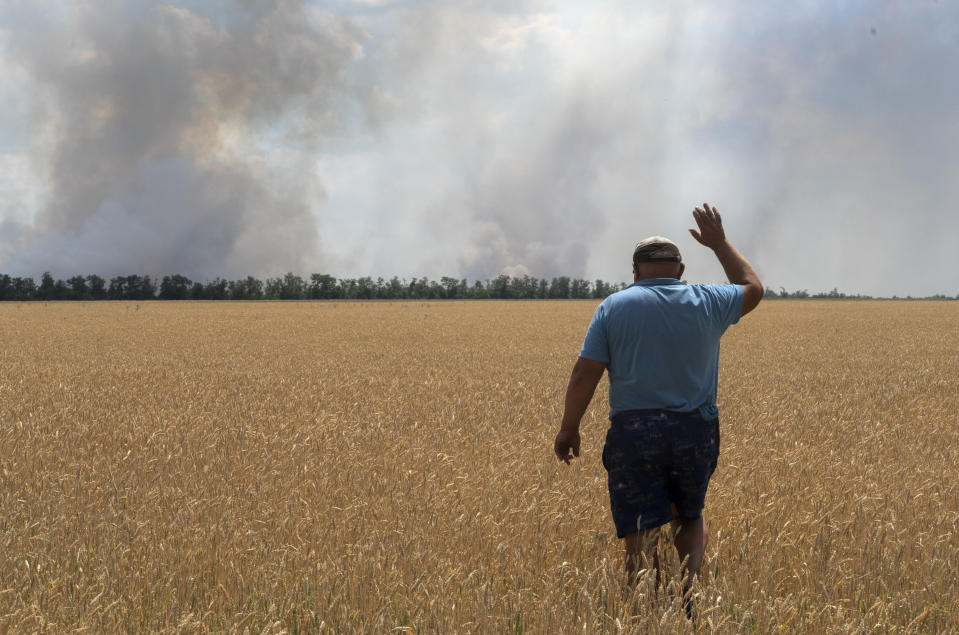 A farmer reacts as he looks at his burning field caused by the fighting at the front line in the Dnipropetrovsk region, Ukraine, Monday, July 4, 2022. An estimated 22 million tons of grain are blocked in Ukraine, and pressure is growing as the new harvest begins. The country usually delivers about 30% of its grain to Europe, 30% to North Africa and 40% to Asia. But with the ongoing Russian naval blockade of Ukrainian Black Sea ports, millions of tons of last year’s harvest still can’t reach their destinations. (AP Photo/Efrem Lukatsky)