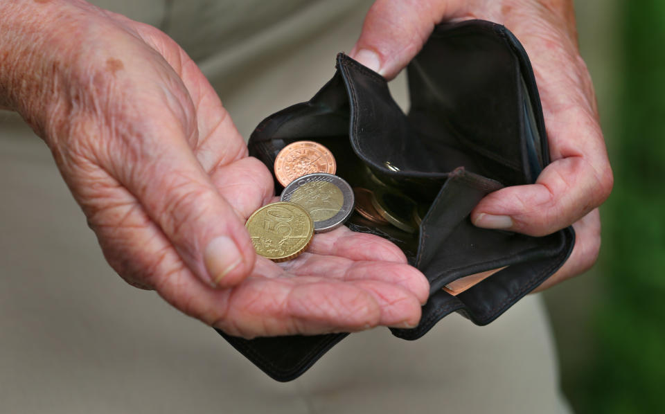 A pensioner holds a wallet with various euro coins in her hands in Kempten, Germany, 13 July 2015. Photo: Karl-Josef Hildenbrand/dpa | usage worldwide   (Photo by Karl-Josef Hildenbrand/picture alliance via Getty Images)