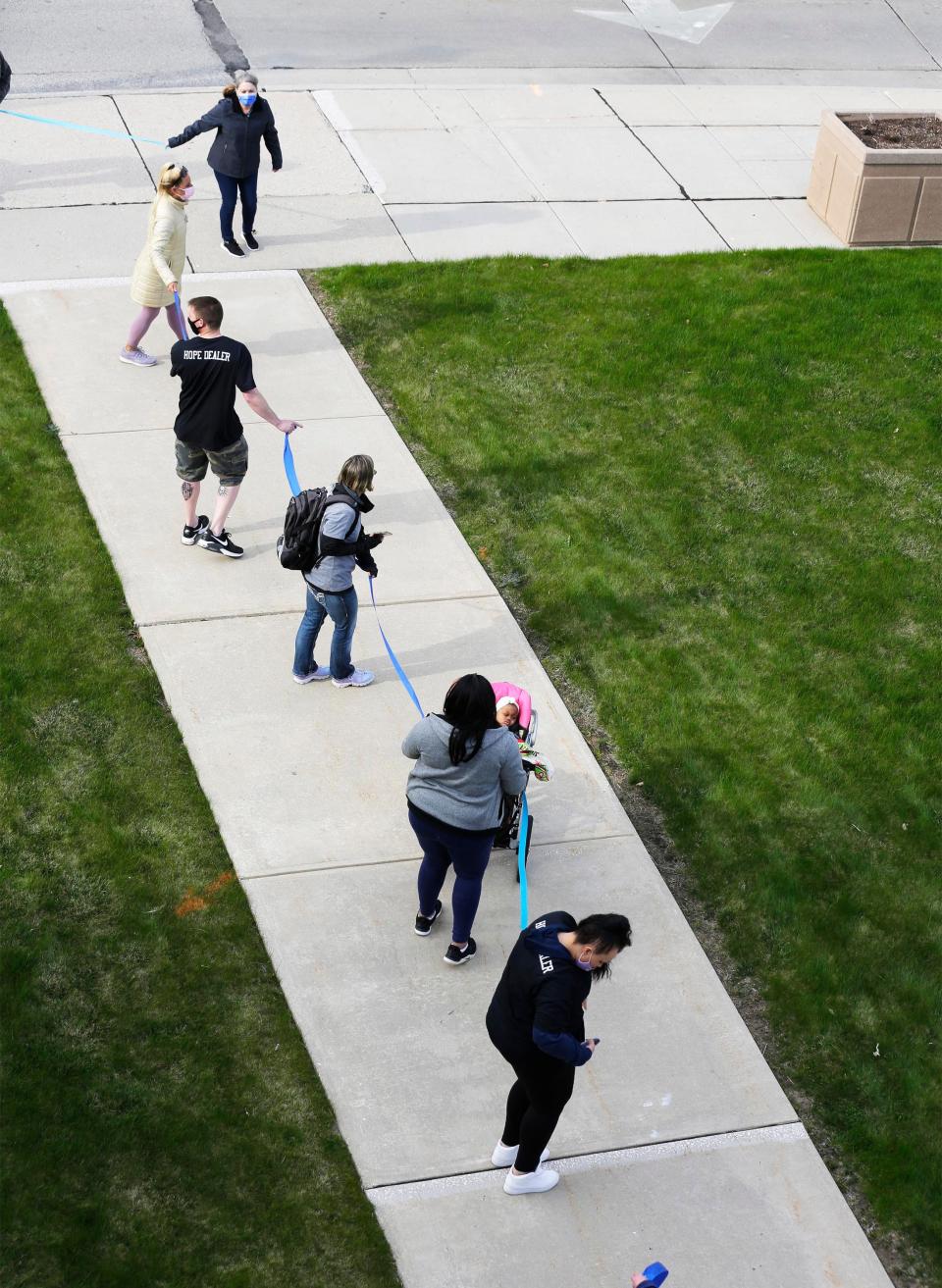 People line the sidewalk around the Manitowoc County Courthouse during the Hands Around the Courthouse, Wednesday, April 28, 2021, in Manitowoc, Wis.  The event highlighted the efforts to prevent child abuse and neglect along with sexual assault awareness.