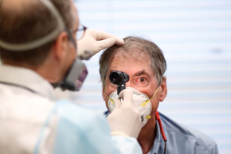 Dr Greg Gulbransen performs a medical checkup on a 72-year-old man with Leukemia who is presumed to have the coronavirus disease (COVID-19) while working in an isolated room at his pediatric practice in Oyster Bay, New York