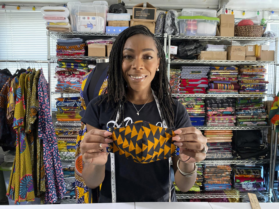 Iguehi James, an Oakland, Calif., fashion entrepreneur, holds a face mask she designed for her apparel company Love Iguehi on Tuesday, Sept. 15, 2020. She received a $5,000 grant from the Oakland African American Chamber of Commerce's "Resiliency Fund," which seeks to help Black-owned businesses stay afloat during the coronavirus pandemic. (AP Photo/Terry Chea)