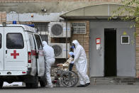 Medical workers wearing protective gear transport a patient suspected of having coronavirus from an ambulance to a hospital in Rostov-on-Don, Russia, Thursday, Oct. 22, 2020. Russia is facing a sharp rise in infections, but the Kremlin has ruled out a new lockdown. (AP Photo)