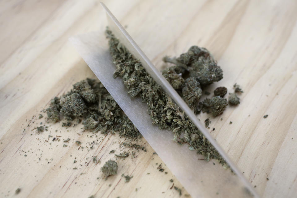 In this June 20, 2018 photo, marijuana and rolling paper used to smoke it, are displayed in New York. A law that took effect on Aug. 12, 2019, sets the maximum penalty to $50 for possessing less than one ounce of pot. It also turns an unlawful marijuana possession statute into a violation that's similar to a traffic ticket, instead of a criminal charge. (AP Photo/Peter Morgan)