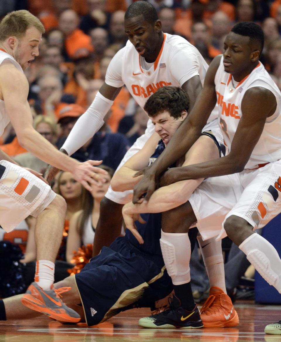 Notre Dame's Tom Knight battles with Syracuse's, from left, Trevor Cooney, Baye Moussa Kieta and Jerami Grant for a loose ball during the second half of an NCAA college basketball game in Syracuse, N.Y., Monday, Feb. 3, 2014. Syracuse won 61-55. (AP Photo/Kevin Rivoli)
