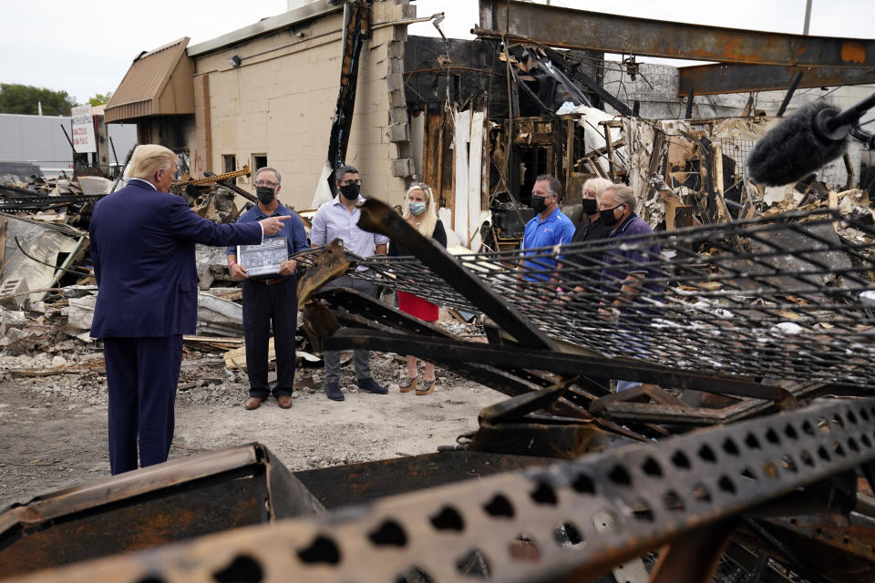 President Donald Trump talks to business owners as he tours an area damaged during demonstrations in Kenosha, Wis. on Sept. 1, 2020.<span class="copyright">Evan Vucci—AP</span>