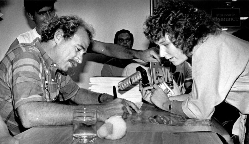 Jimmy Buffet signs a poster for an admiring fan during a T-shirt promotion in Miami in 1984.