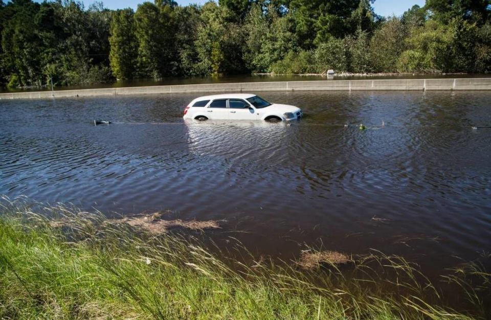 A stranded car rests in flood waters where the Lumber River flows over Interstate 95 Monday, October 10, 2016 after Hurricane Matthew caused downed trees power outages and massive flooding in Lumberton, NC.