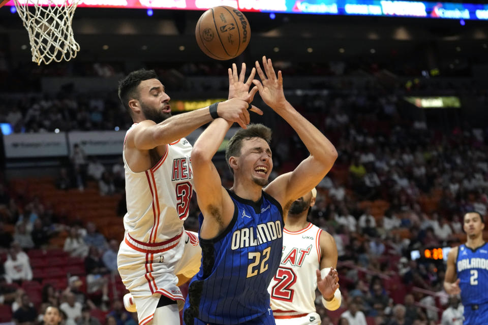 Orlando Magic forward Franz Wagner (22) is fouled by Miami Heat guard Max Strus during the first half of an NBA basketball game, Sunday, April 9, 2023, in Miami. (AP Photo/Lynne Sladky)