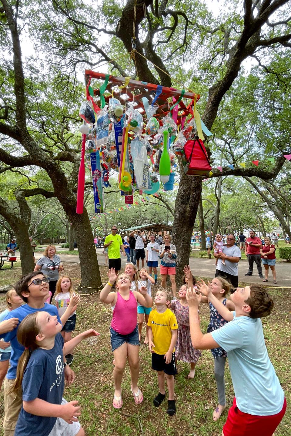 Children jump for toys and treats from a piñata Saturday during the town of Shalimar's 75th anniversary celebration at Combs Park.