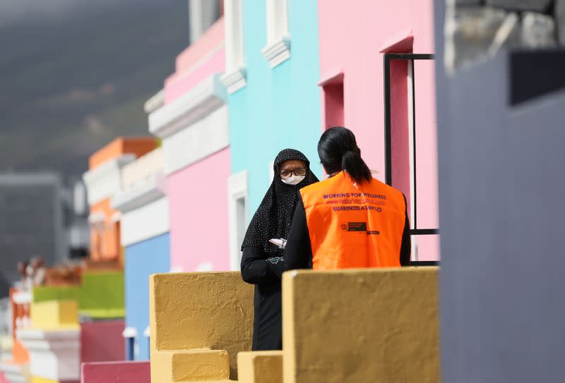 A health worker talks to residents as they conduct screening during the 21-day nationwide lockdown aimed at limiting the spread of coronavirus disease (COVID-19) in Bo Kaap, Cape Town