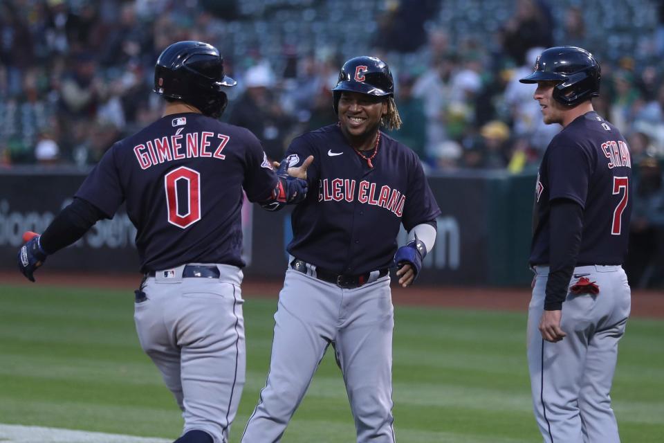 Cleveland Guardians' Andres Gimenez (0) is congratulated by Jose Ramirez, center, and Myles Straw, right, after hitting a grand slam against the Oakland Athletics during the third inning of a baseball game in Oakland, Calif., Friday, April 29, 2022. (AP Photo/Jed Jacobsohn)