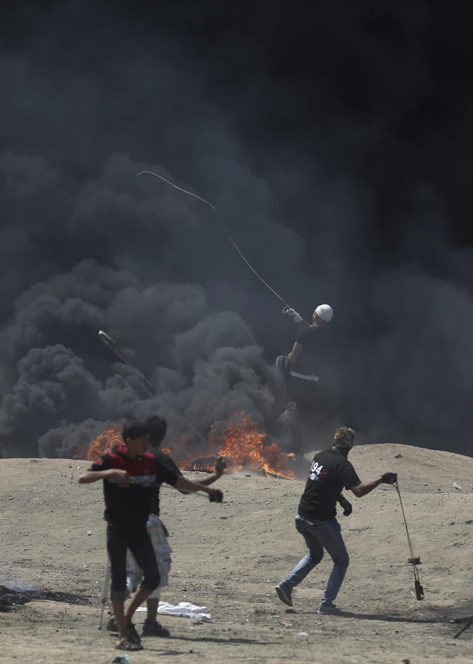 Palestinian protesters hurl stones at Israeli troops during the protest (Picture: AP)