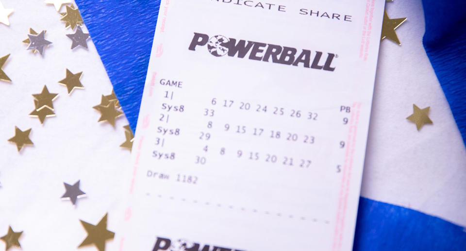 A powerball ticket sits on a table surrounded by streamers and confetti. Source: The Lott