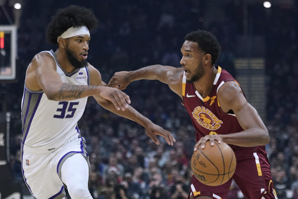 Cleveland Cavaliers' Evan Mobley, right, drives against Sacramento Kings' Marvin Bagley III during the first half of an NBA basketball game Saturday, Dec. 11, 2021, in Cleveland. (AP Photo/Tony Dejak)