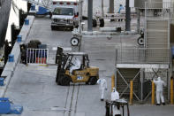 Workers in protective gear remove luggage form Carnavil's Holland America cruise ship Zaandam as it is docked at Port Everglades during the new coronavirus pandemic, Thursday, April 2, 2020, in Fort Lauderdale, Fla. Those passengers that are fit for travel in accordance with guidelines from the U.S. Centers for Disease Control will be permitted to disembark. (AP Photo/Lynne Sladky)