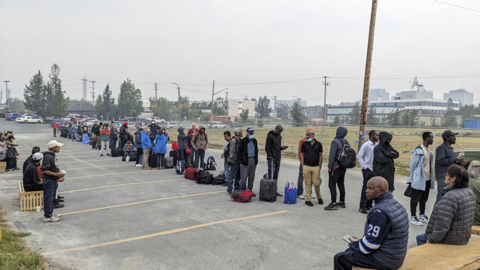 People without vehicles lineup to register for a flight to Calgary, Alberta in Yellowknife on Thursday, Aug. 17, 2023. Prime Minister Justin Trudeau is expected to convene an urgent meeting with ministers and senior officials today as residents of the capital of Northwest Territories are ordered to evacuate the area because of an encroaching wildfire. (Bill Braden /The Canadian Press via AP)