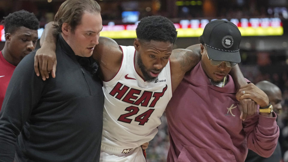 Miami Heat forward Haywood Highsmith (24) is helped off the court after being injured during the second half of an NBA basketball game against the Utah Jazz, Saturday, Dec. 30, 2023, in Salt Lake City. (AP Photo/Rick Bowmer)