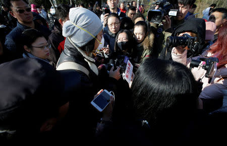 A parent is surrounded by members of the media outside the kindergarten run by pre-school operator RYB Education Inc being investigated by China's police, in Beijing, China November 24, 2017. REUTERS/Jason Lee