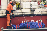 Italian firefighter divers bring ashore in a plastic bag the body of one of the victims of a shipwreck, in Porticello, Sicily, southern Italy, Thursday, Aug. 22, 2024. Divers searching the wreck of the superyacht Bayesian that sank off Sicily on Monday recovered a fifth body on Thursday and continued to search for one more as investigators sought to learn why the vessel sank so quickly. (AP Photo/Salvatore Cavalli)