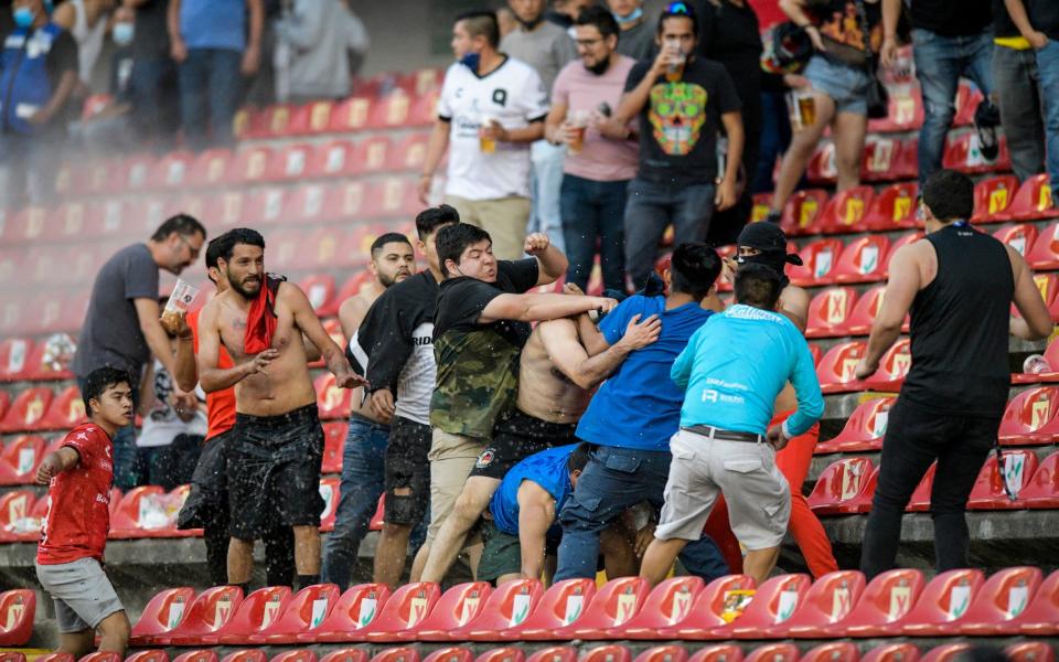 Fans clash during a Mexican soccer league match between the host Queretaro and Atlas from Guadalajara, at the Corregidora stadium, in Queretaro, Mexico, Saturday, March 5, 2022 - AP