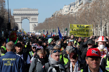 Protesters wearing yellow vests march down the Champs Elysees from the Arc de Triomphe during a demonstration by the "yellow vests" movement in Paris, France, February 23, 2019. REUTERS/Philippe Wojazer