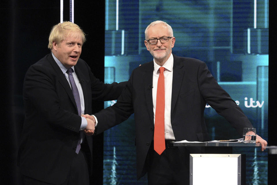 In this photo issued by ITV, Boris Johnson, left, and Jeremy Corbyn, right, shake hands during their election head-to-head debate live on TV, in Manchester, England, Tuesday, Nov. 19, 2019. Prime Minister Boris Johnson and Jeremy Corbyn are set to go head-to-head in their first live televised debate Tuesday evening, as the UK prepares for a General Election on Dec. 12. (ITV via AP)