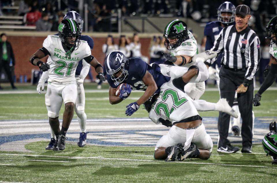 Georgia Southern running back OJ Arnold (22 in blue) drives for yards against Marshall safety Kerion Martin (22 in white).