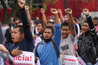 Supporters and relatives of 43 missing university students hold placards with photos of their loved ones as they march on the seventh anniversary of their disappearance, in Mexico City, Sunday, Sept. 26, 2021. Relatives continue to demand justice for the Ayotzinapa students who were allegedly taken from the buses by the local police and handed over to a gang of drug traffickers. (AP Photo/Marco Ugarte)