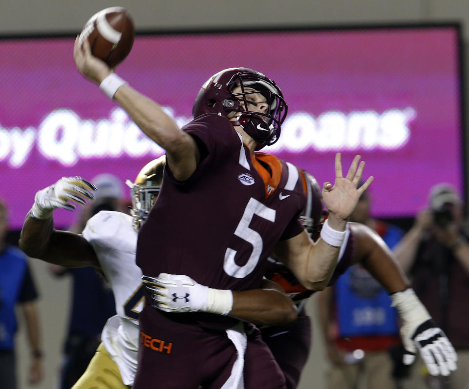 Virginia Tech quarterback Ryan Willis (5) gets off a pass as Notre Dame defensive lineman Julian Okwara, left, closes in during the first half of an NCAA college football game in Blacksburg, Va., Saturday, Oct. 6, 2018. (AP Photo/Steve Helber)