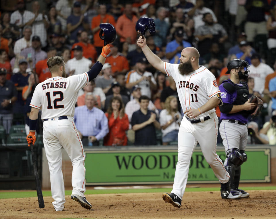 Houston Astros' Evan Gattis (11) celebrates with Max Stassi (12) after hitting a home run during the fifth inning of a baseball game against the Colorado Rockies on Wednesday, Aug. 15, 2018, in Houston. (AP Photo/David J. Phillip)