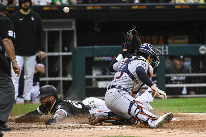 Chicago White Sox 's Leury Garcia, bottom left, scores past Detroit Tigers catcher Eric Haase, right, during the second inning of a baseball game, Saturday, Aug. 13, 2022, in Chicago. (AP Photo/Matt Marton)