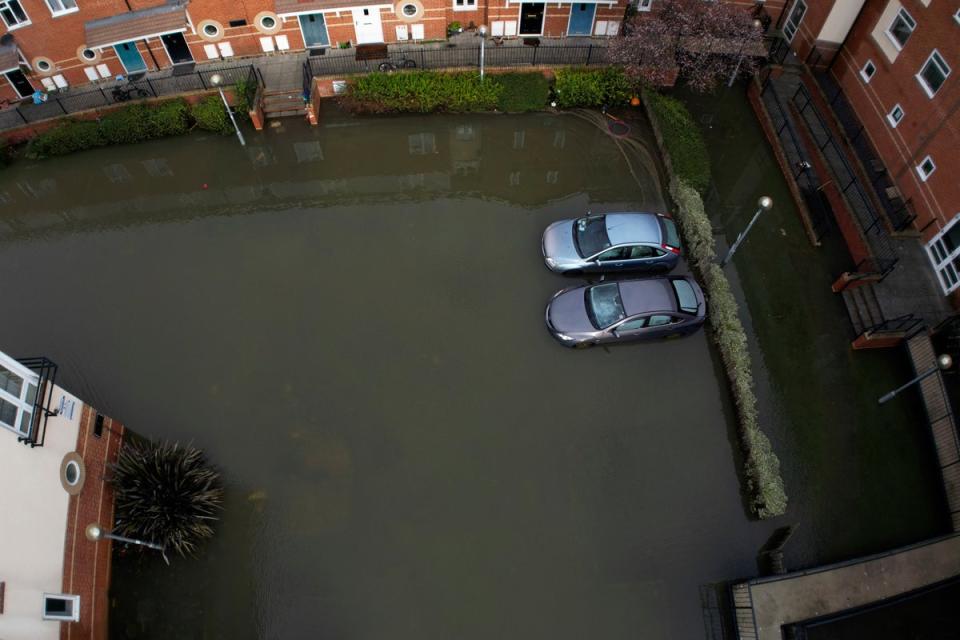 Cars stuck in the floods in a parking area near the River Thames in Oxford on Sunday (AP)