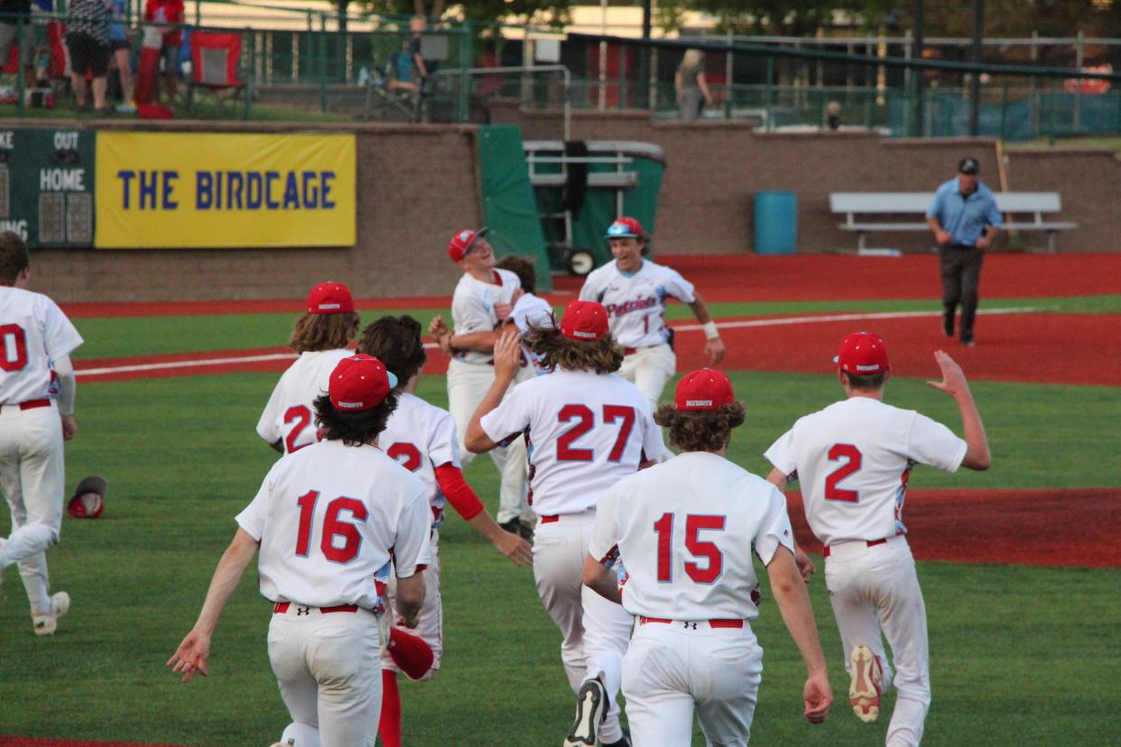 Lincoln Patriots players tackle pitcher Lincoln Vasgaard after he pitched a complete game in the state championship game on Saturday at the Birdcage. Lincoln beat Mitchell 6-1.