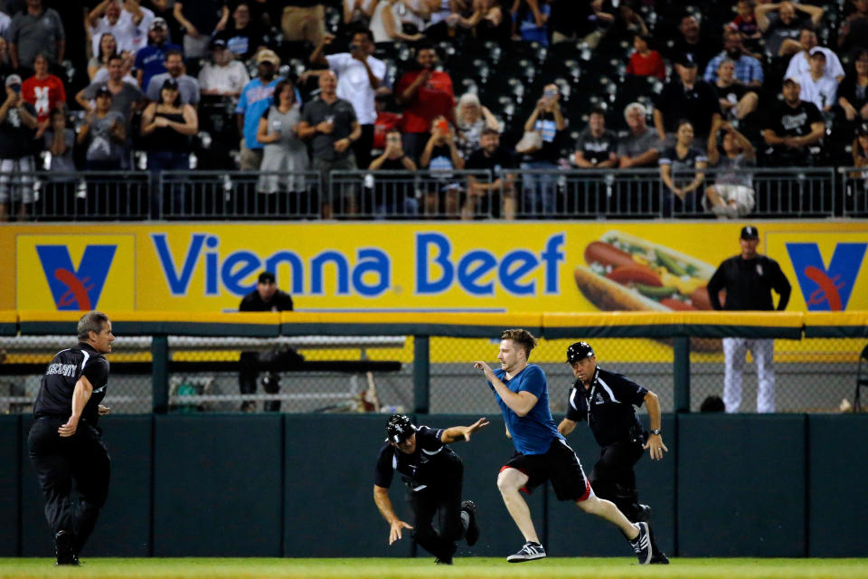 Chicago White Sox security chases one of the three fans that ran onto the field during the ninth inning of the game between the Chicago White Sox and the Seattle Mariners at U.S. Cellular Field on August 25, 2016 in Chicago, Illinois. (Photo by Jon Durr/Getty Images)