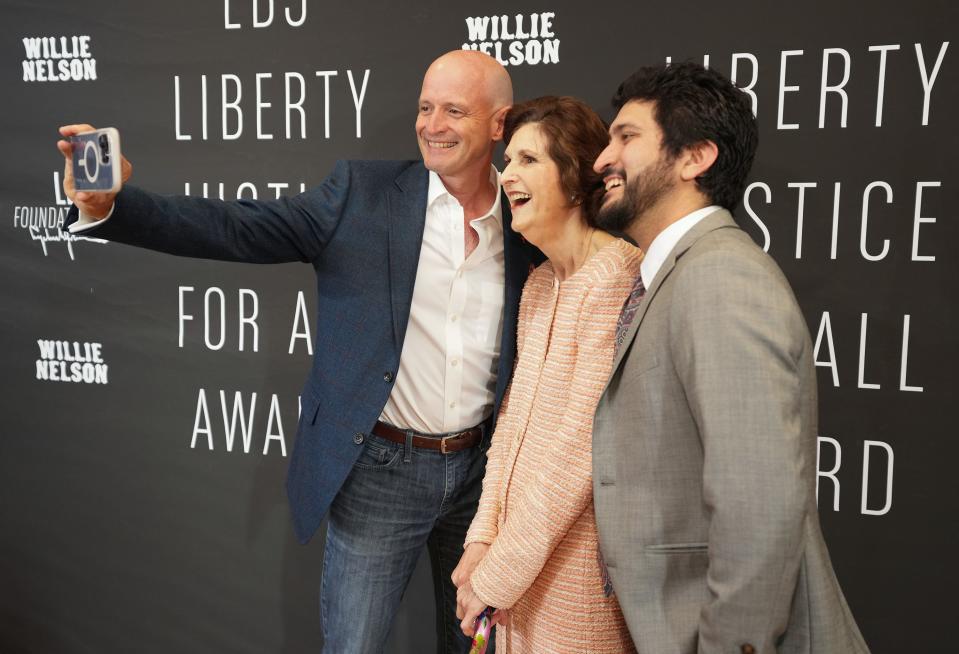 JR DeShazo, dean of the LBJ School of Public Affairs, left, Lynda Johnson Robb, daughter of President Lyndon B. Johnson, and U.S. Rep Greg Casar take a selfie at a gala where Willie Nelson received the LBJ Liberty and Justice For All Award.