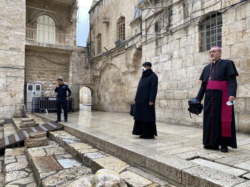 Archbishop Pierbattista Pizzaballa, apostolic administrator of the Latin Patriarchate of Jerusalem stands at the entrance to the Church of the Holy Sepulchre for the Good Friday service amid restrictions due to the coronavirus disease (COVID-19) in Jerusal