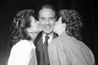 FILE - In this Nov. 28, 1984, file photo, newly elected Senate Majority Leader Dole, of Kansas, is kissed by his wife, Transportation Secretary Elizabeth Dole and his daughter, Robin, on Capitol Hill in Washington. Bob Dole, who overcame disabling war wounds to become a sharp-tongued Senate leader from Kansas, a Republican presidential candidate and then a symbol and celebrant of his dwindling generation of World War II veterans, has died. He was 98. His wife, Elizabeth Dole, posted the announcement Sunday, Dec. 5, 2021, on Twitter. (AP Photo/Ira Schwarz, File)