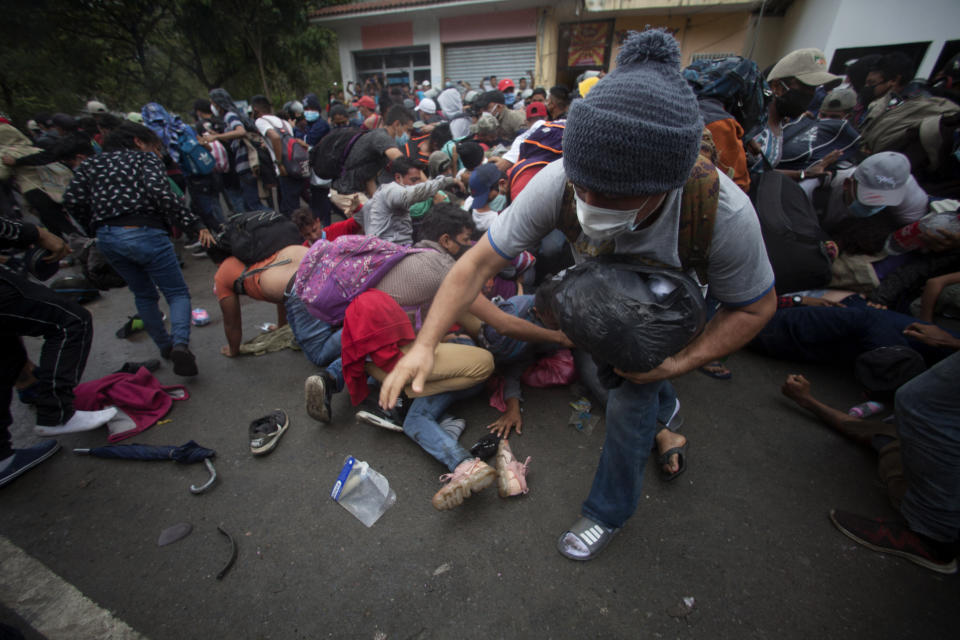 Honduran migrants hoping to reach the U.S. scramble to cross the border patrolled by Guatemalan soldiers, in El Florido, Guatemala, Saturday, Jan. 16, 2021. The migrants pushed their way into Guatemala Friday night without registering, a portion of a larger migrant caravan that had left the Honduran city of San Pedro Sula before dawn, Guatemalan authorities said. (AP Photo/Sandra Sebastian)