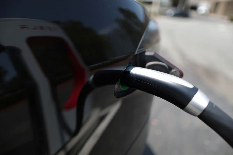 A Tesla is charged at an electric car supercharger station in Los Angeles