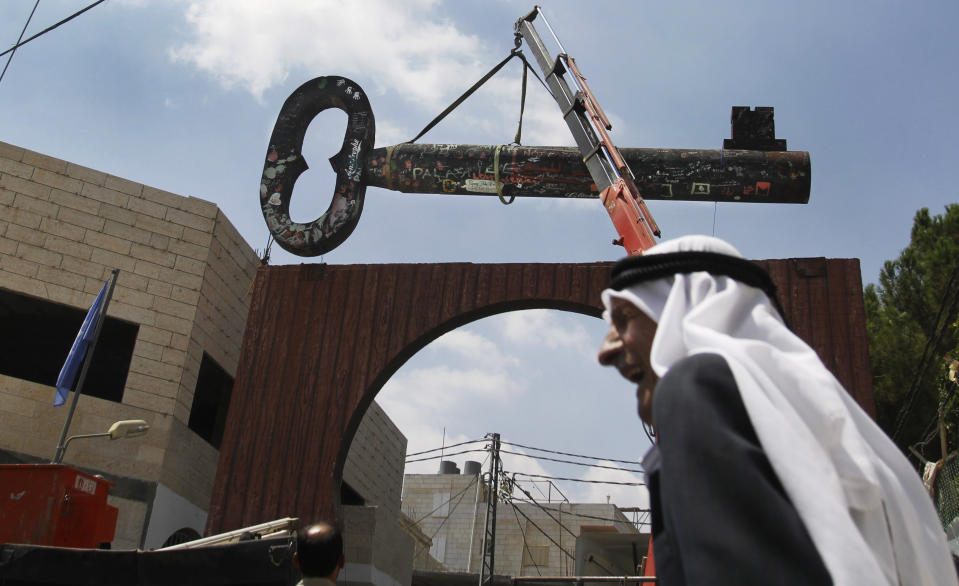 FILE - Palestinians display a huge key, known as "the Key of Return," which was exhibited at the Berlin Biennale in March 2012, in the West Bank refugee camp of Aida near Bethlehem, Aug. 29. The key symbolizes what the Palestinians call their "right of return" to properties lost during the 1948 war surrounding Israel's creation. A growing number of Black Americans see the struggle of Palestinians reflected in their own fights for freedom and civil rights. The rise of protest movements against police brutality in the U.S., where structural racism plagues nearly every facet of life, has connected Black and Palestinian activists under a common cause. (AP Photo/Nasser Shiyoukhi, File)