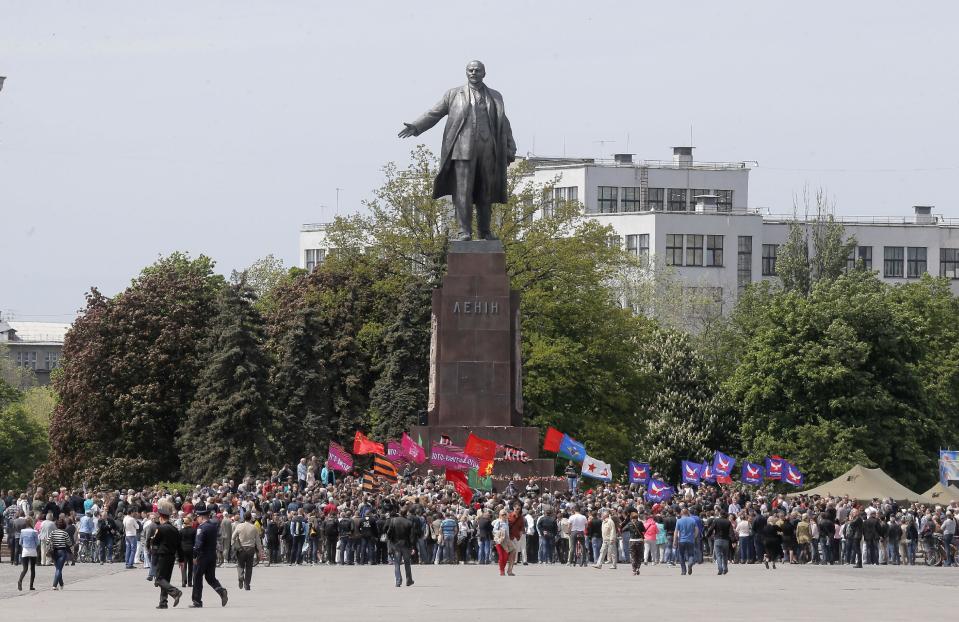 Ukrainians take part in a rally in front of a monument of Soviet revolutionary leader Vladimir Lenin, during a Victory Day celebration, which commemorates the 1945 defeat of Nazi Germany, in Kharkiv, Ukraine, Friday, May 9, 2014. Putin's surprise call on Wednesday for delaying the referendum in eastern Ukraine appeared to reflect Russia's desire to distance itself from the separatists as it bargains with the West over a settlement to the Ukrainian crisis. But insurgents in the Russian-speaking east defied Putin's call and said they would go ahead with the referendum. (AP Photo/Efrem Lukatsky)