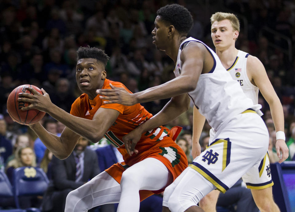 Miami's Anthony Walker (11) looks for a shot with pressure from Notre Dame's Juwan Durham during the first half of an NCAA college basketball game Sunday, Feb. 23, 2020, in South Bend, Ind. (AP Photo/Robert Franklin)