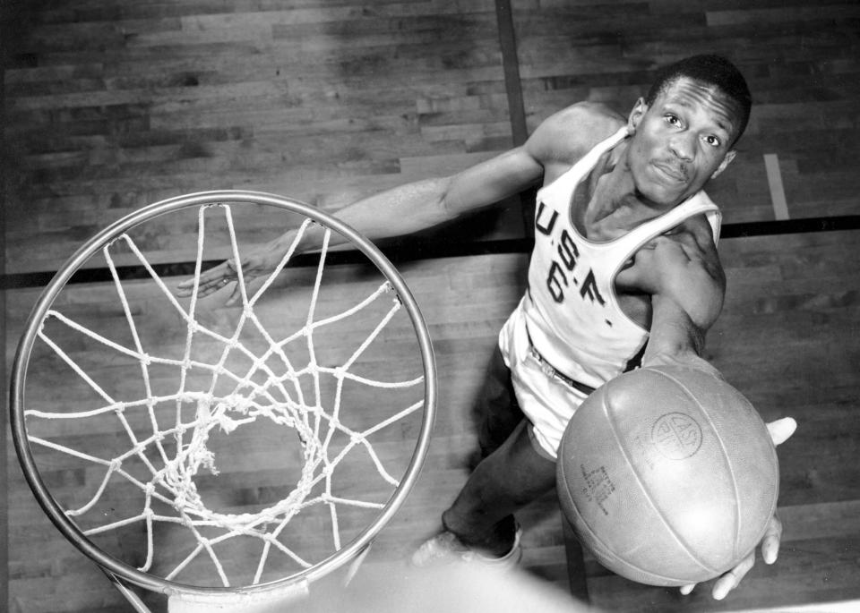 FILE - San Francisco NCAA college basketball player Bill Russell shows how he scores baskets, Feb. 23, 1956. The 6-foot-10 center had one of most dominating NCAA Tournament games in history during the 1956 title game, finishing with 26 points and 27 rebounds in a win over Iowa. He also was believed to have swatted at least a dozen shots, though blocked shots were not yet an official stat. (AP Photo/File)