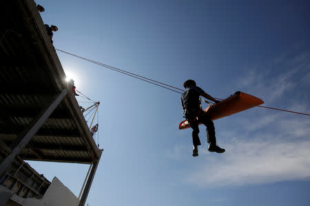 A rescue worker is suspended on a cable during an earthquake drill during the first anniversary of the September 2017 earthquake, in Ciudad Juarez, Mexico September 19, 2018. REUTERS/Jose luis Gonzalez