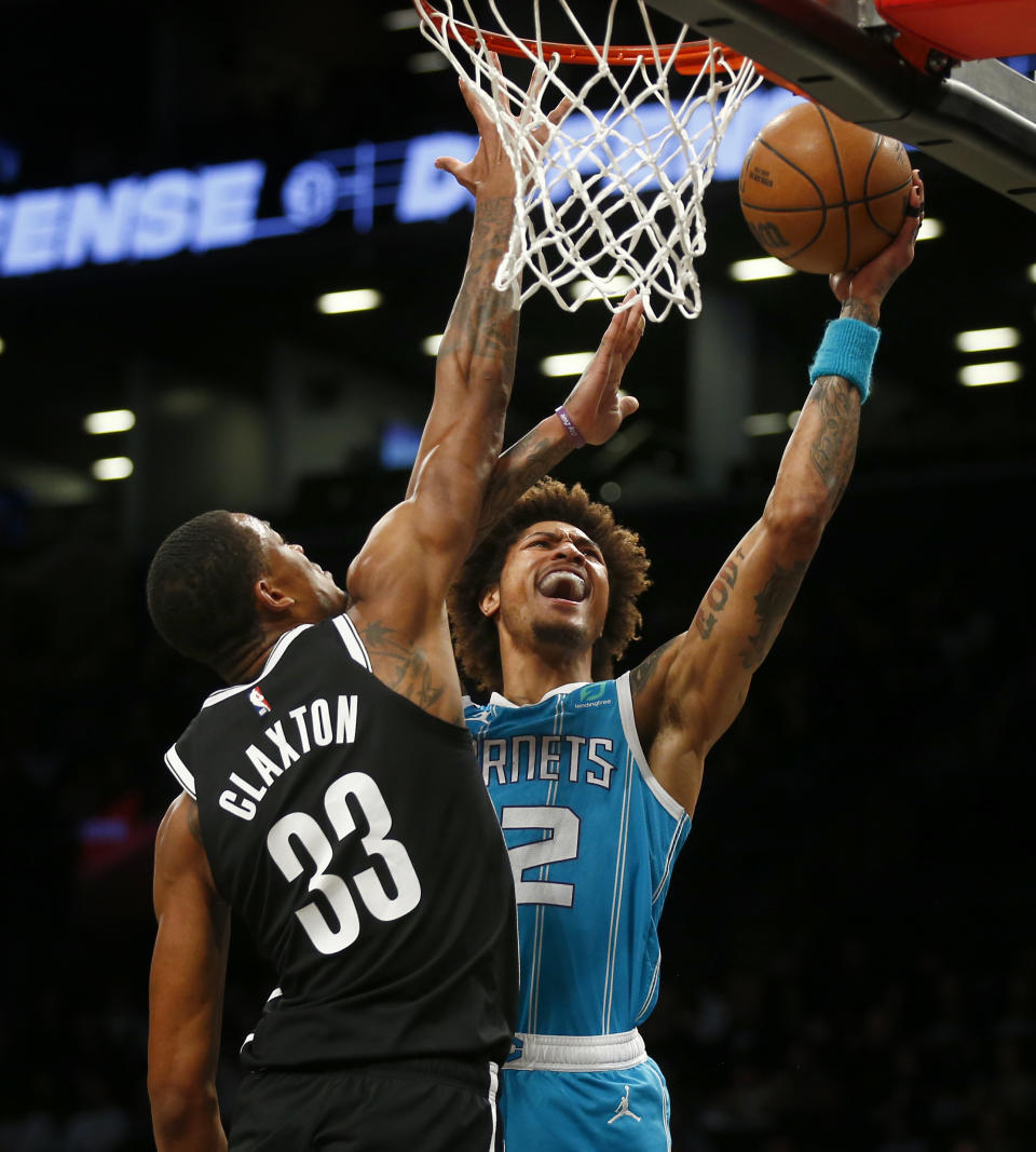 Charlotte Hornets forward Kelly Oubre Jr. (12) shoots over Brooklyn Nets canter Nic Claxton (33) during the first half of an NBA basketball game Sunday, March 5, 2023, in New York. (AP Photo/John Munson)