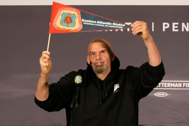 Fetterman holds up an Eastern Atlantic States Regional Council of Carpenters flag as he begins his speech Monday at a Carpenters Union Hall in Pittsburgh. (Photo: Gene J. Puskar/Associated Press)