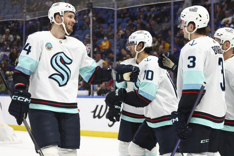 Seattle Kraken defensemen Justin Schultz (4) and Will Borgen (3) celebrate a goal by center Matty Beniers (10) against the Buffalo Sabres during the second period of an NHL hockey game Tuesday, Jan. 9, 2024, in Buffalo, N.Y. (AP Photo/Jeffrey T. Barnes)